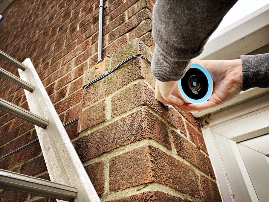 Person installing a smart home security camera.